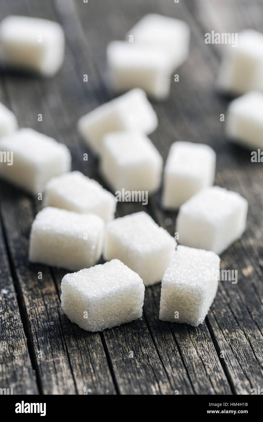 Cubes de sucre blanc sur la vieille table en bois. Banque D'Images