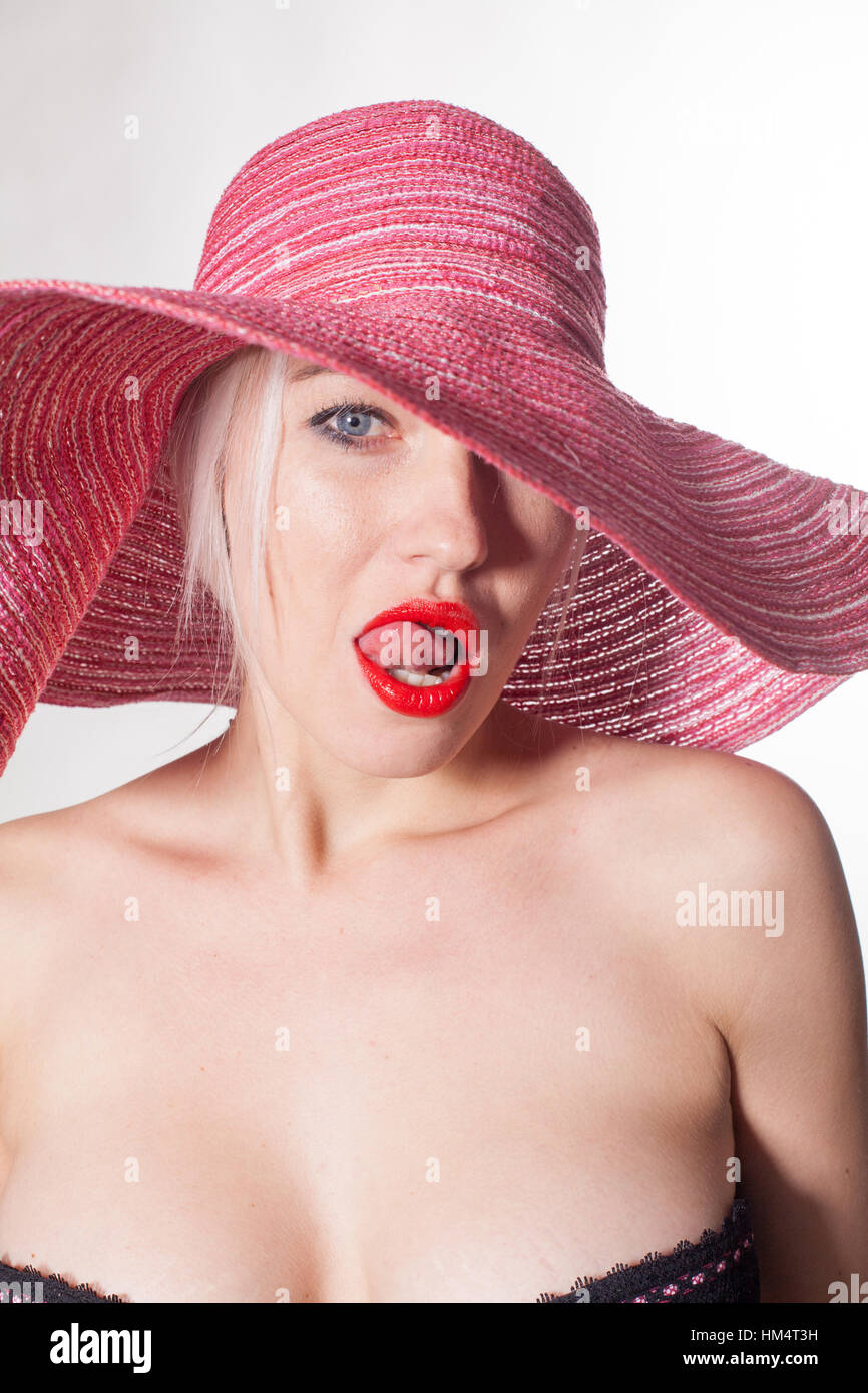 Femme avec un chapeau rouge lèvres langue Banque D'Images