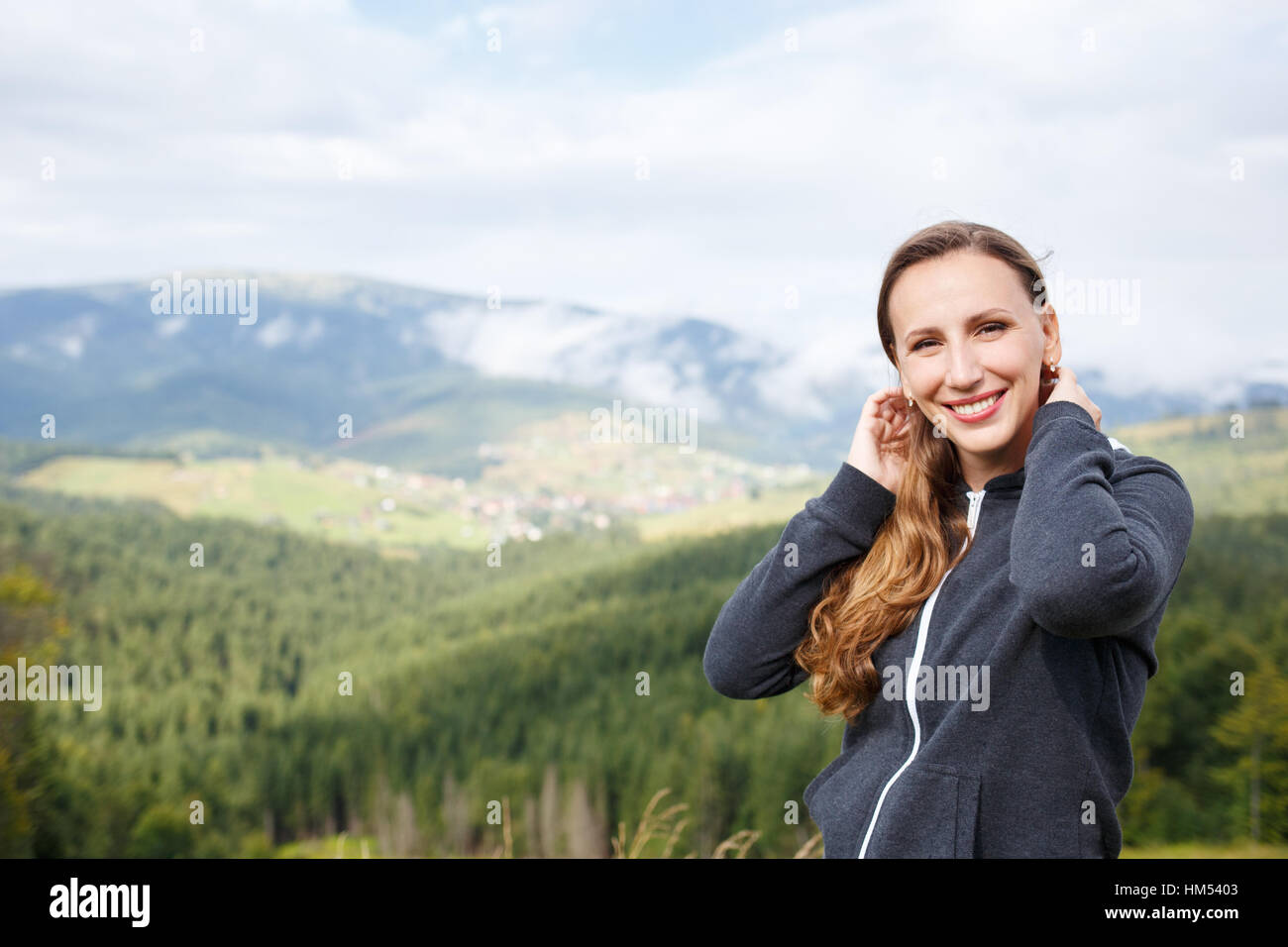 Portrait of young smiling woman in mountains Banque D'Images