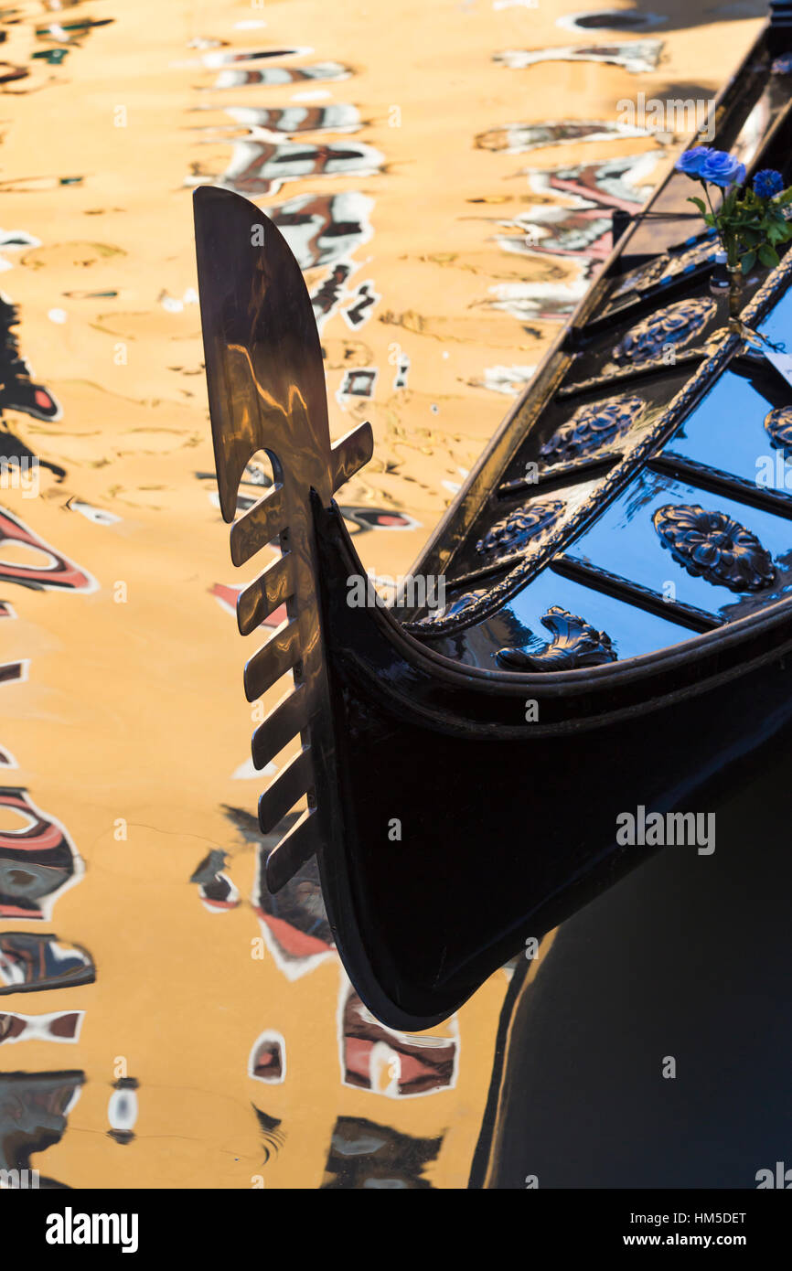 Gondola détail dans la lumière du soleil d'Or avec reflets du bâtiment dans l'eau à Venise, Italie en janvier Banque D'Images