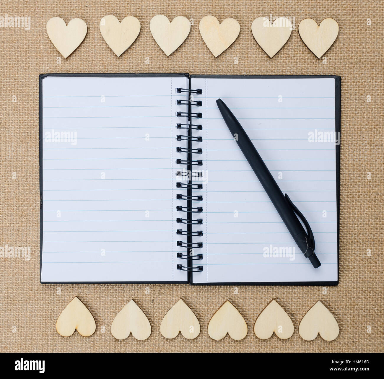 Coeurs en bois sur fond de texture de Hesse, Valentine. Bloc-notes avec stylo Banque D'Images