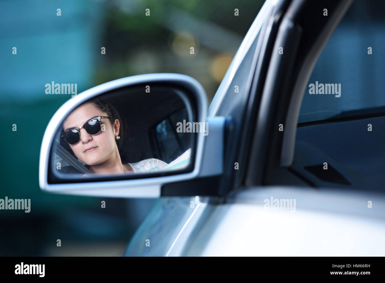 Jeune femme conducteur de regarder à l'arrière de la voiture mirrow Banque D'Images