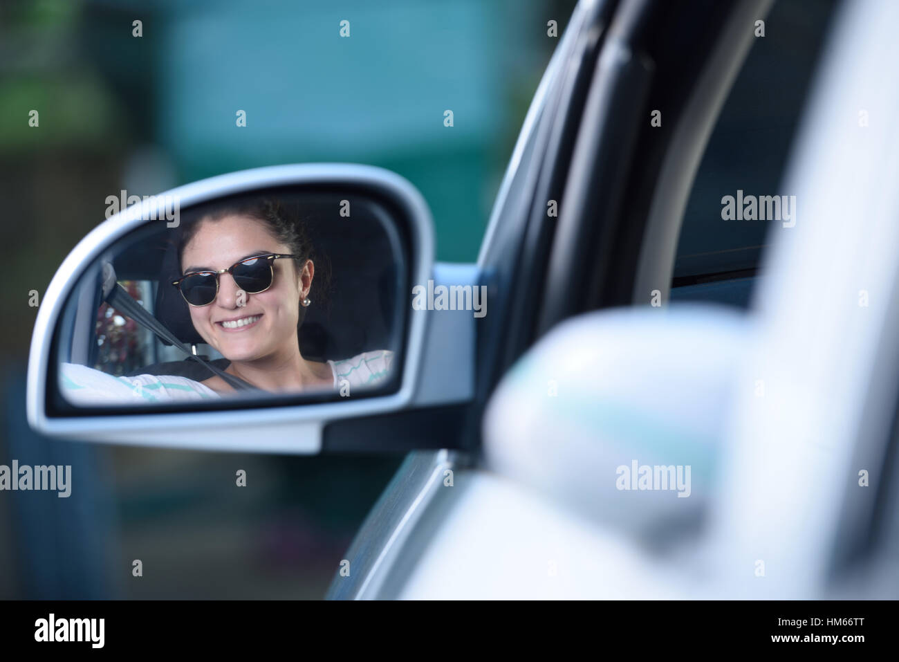 Conduire une voiture de fille et sa réflexion sur le rétroviseur extérieur Banque D'Images