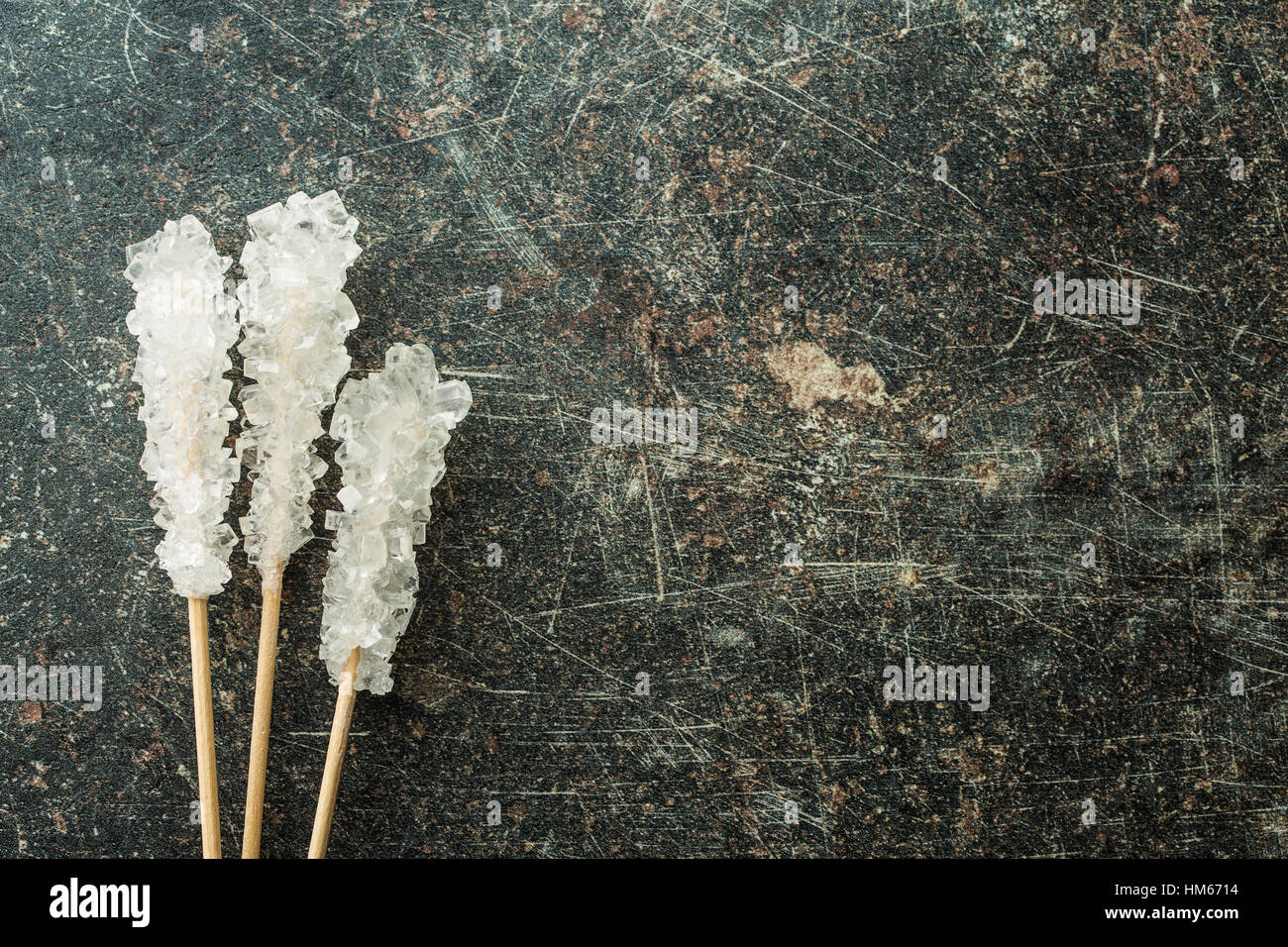 Le sucre cristallisé sur bâton en bois sur la vieille table de cuisine. Vue d'en haut. Banque D'Images