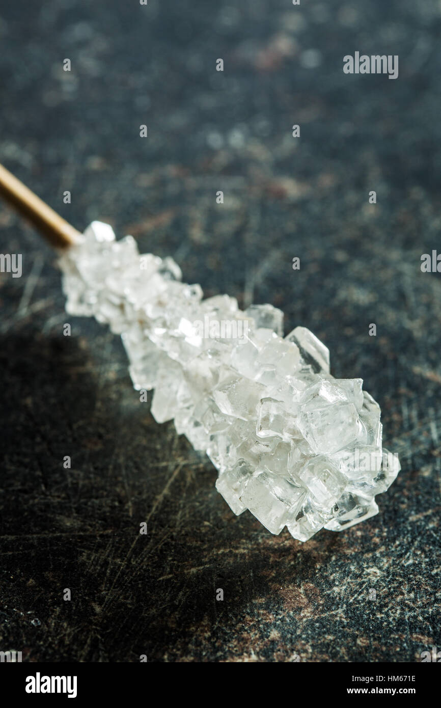 Le sucre cristallisé sur bâton en bois sur la vieille table de cuisine. Banque D'Images