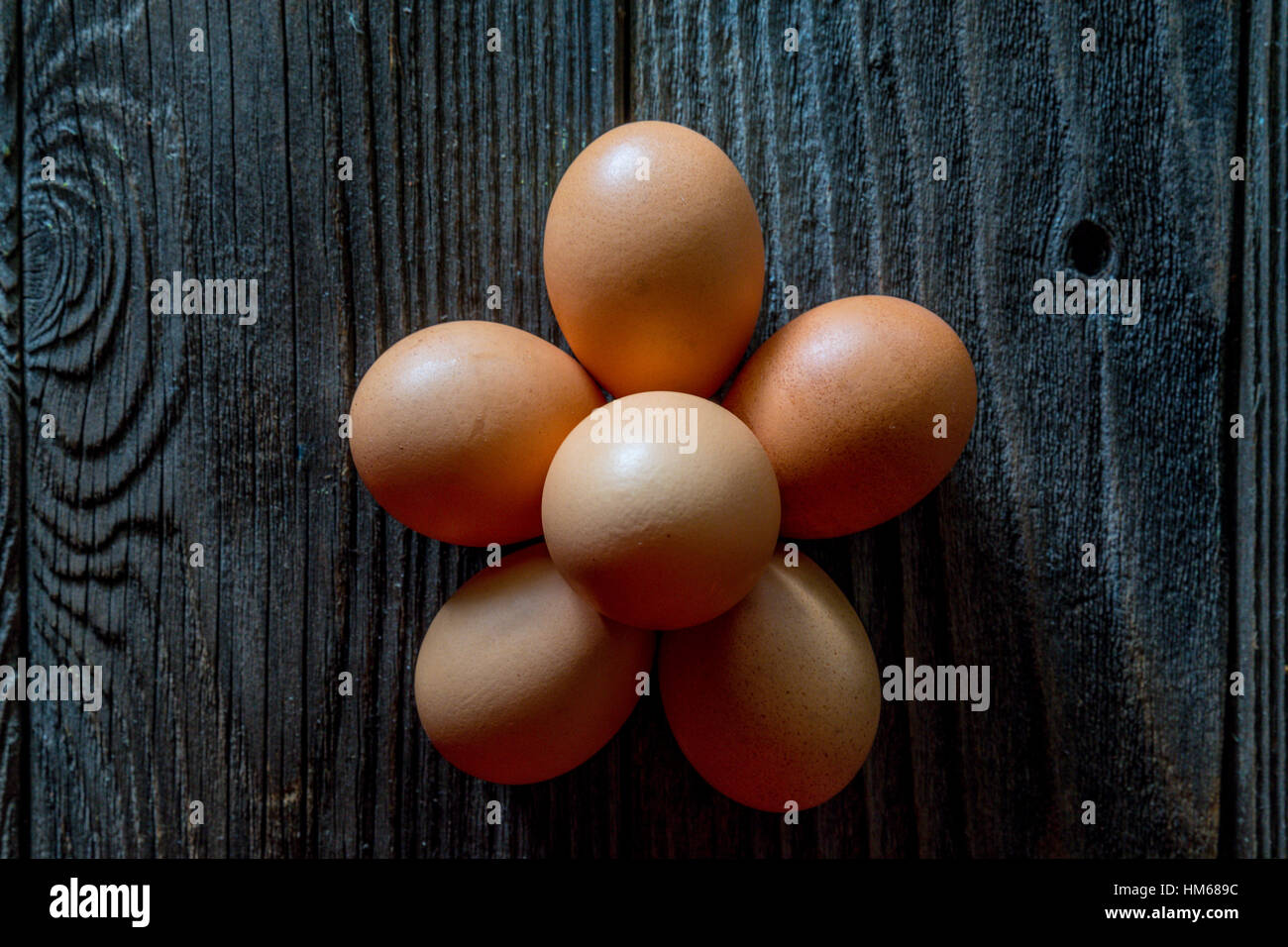 Une demi-douzaine d'œufs sur une table en bois rustique Banque D'Images
