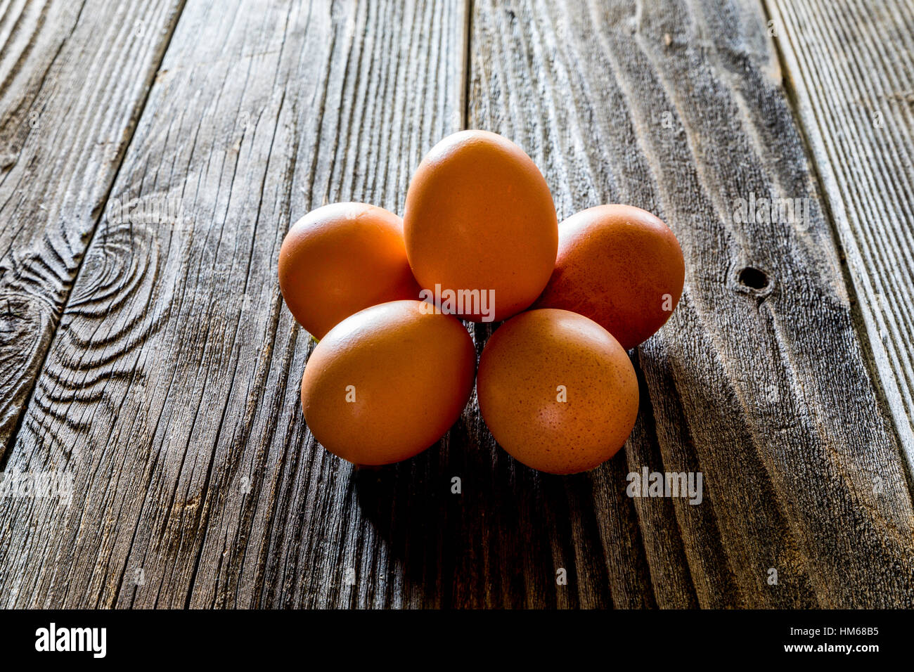 Une demi-douzaine d'œufs sur une table en bois rustique Banque D'Images