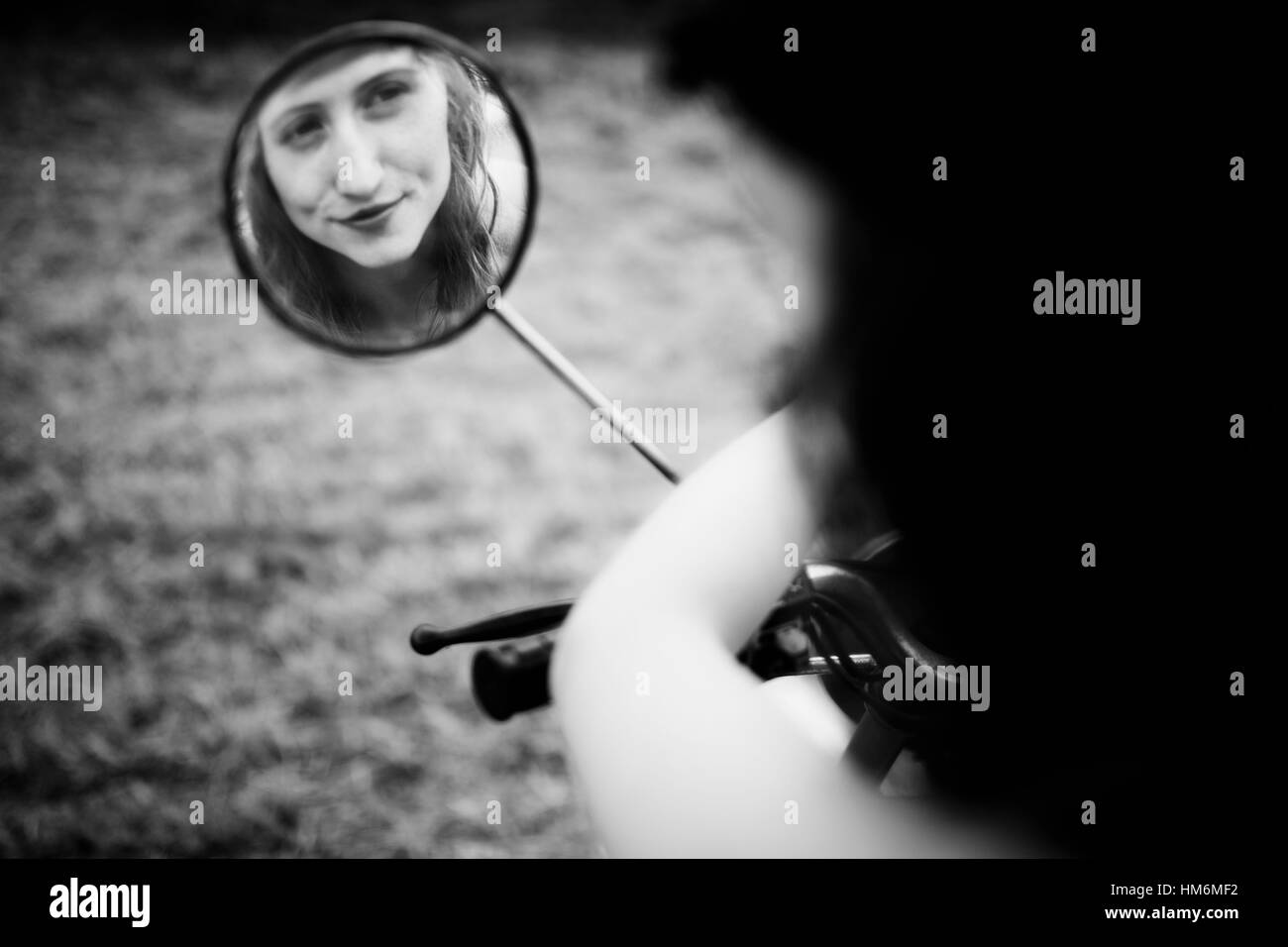 Femme cherche en miroir, la réflexion de moto Banque D'Images
