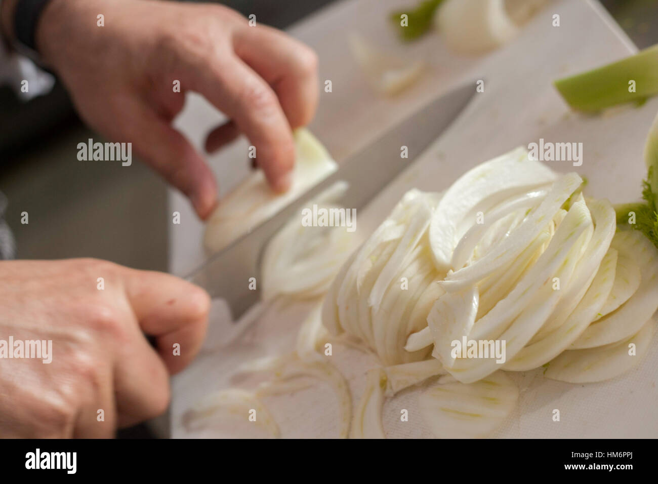 Couper les oignons avec Chef knife on white board Banque D'Images