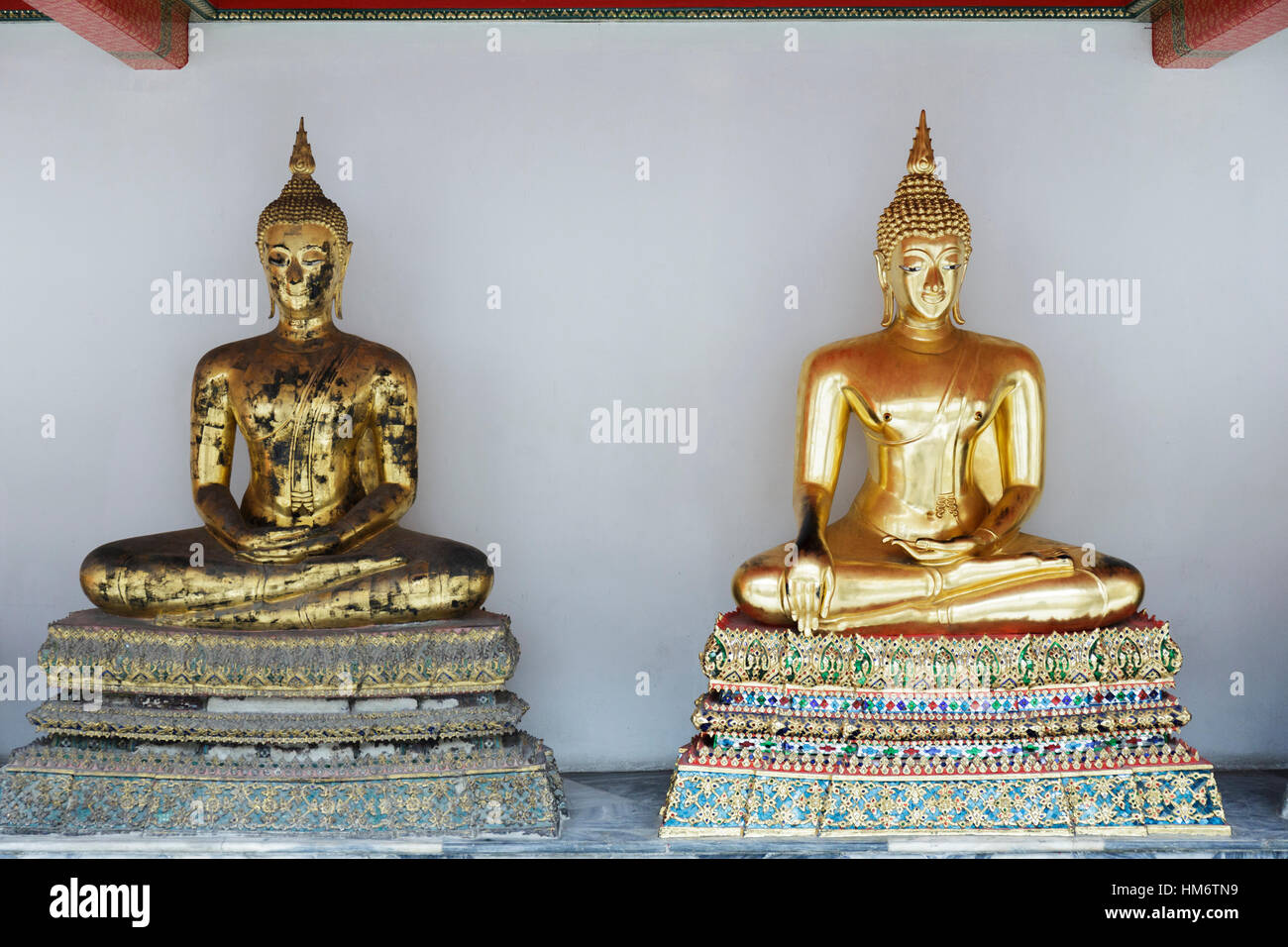 Statues de Bouddha en or contre mur de temple Banque D'Images