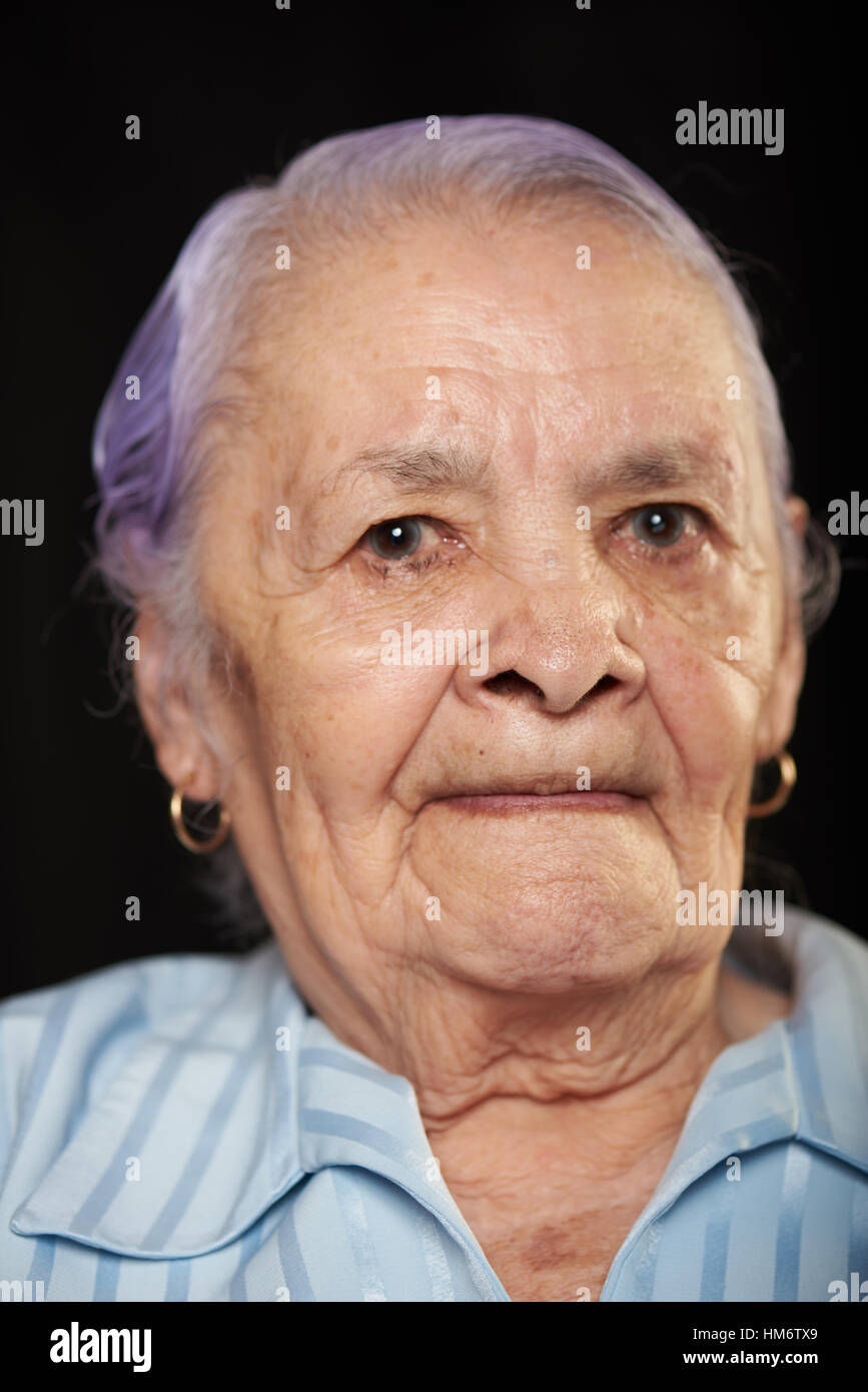 Grand-mère à la maladie de parkinson isolé sur fond noir Banque D'Images