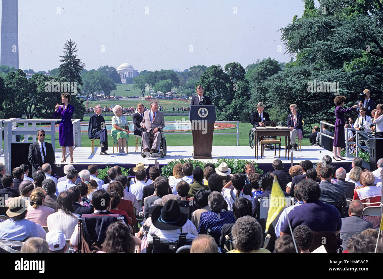 Le président des États-Unis George H. W. Bush signe la Loi sur les Américains handicapés de 1990 dans la loi au cours d'une cérémonie à la Maison Blanche à Washington, D.C. le 26 juillet 1990. Sur la photo, sur scène, (de gauche à droite) : interprète non identifiés Banque D'Images