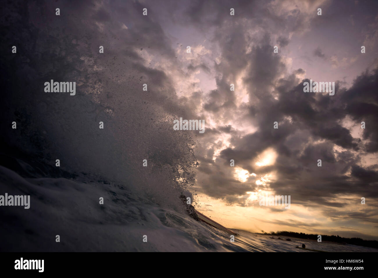 Éclaboussures des vagues en mer contre ciel nuageux pendant le coucher du soleil Banque D'Images