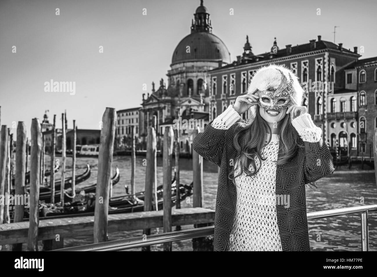 Un autre monde de vacances. Portrait of smiling woman in fur hat élégant à Venise, Italie portant masque de Venise Banque D'Images