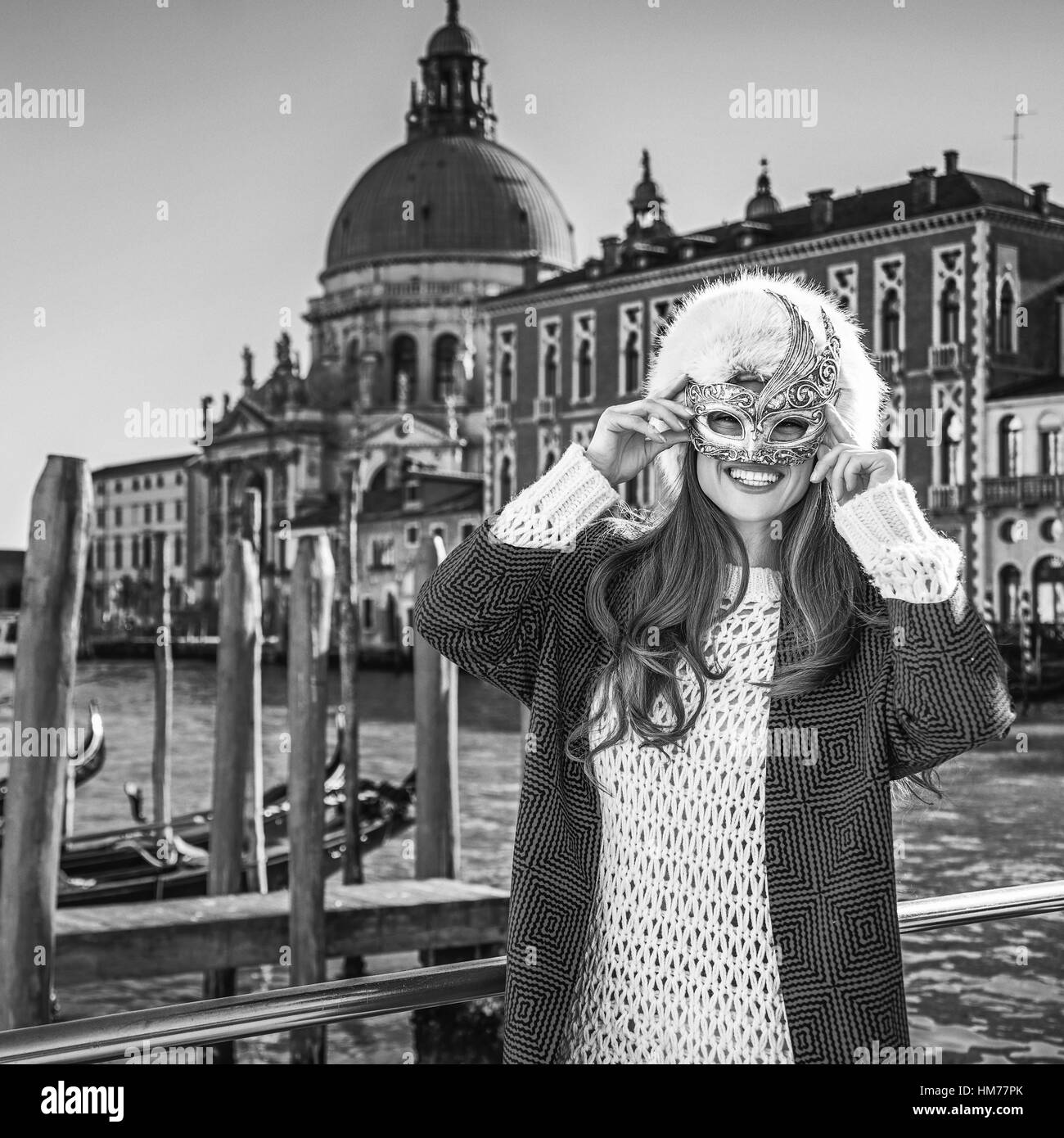 Un autre monde de vacances. Portrait of smiling woman in fur hat élégant à Venise, Italie portant masque de Venise Banque D'Images