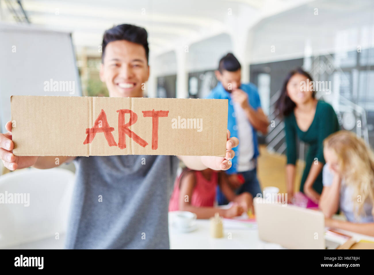 Avec l'étudiant est titulaire d'inscription mot 'art' sur elle dans l'atelier d'idées créatives Banque D'Images