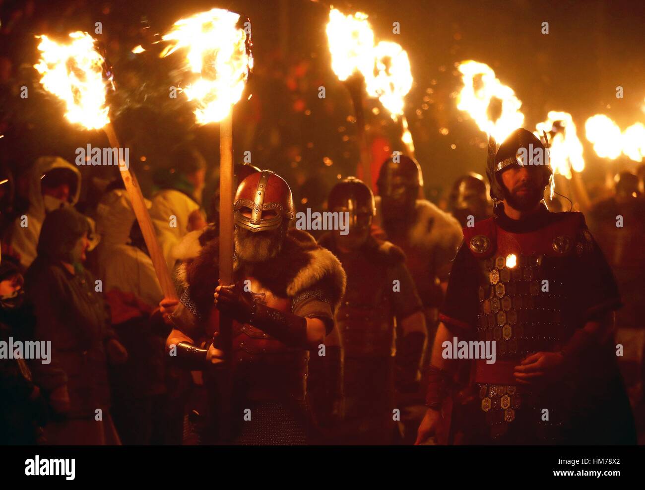 Les membres de l'équipe de Jarl vêtus de costumes de Vikings portent des torches enflammées au cours de l'Up Helly Aa festival viking à Lerwick sur les îles Shetland. Banque D'Images