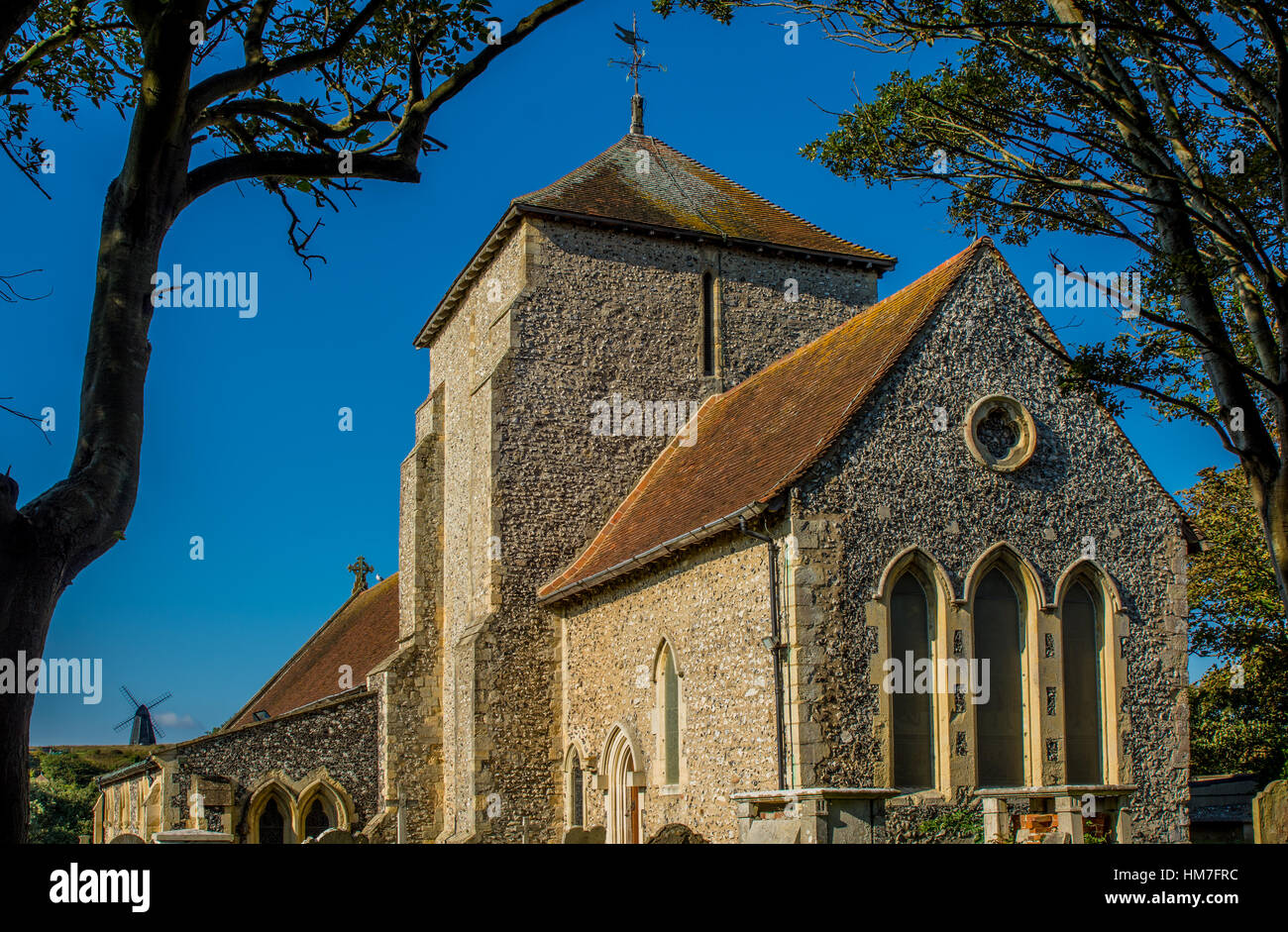 L'église Sainte-Marguerite à Rottingdean, East Sussex, Angleterre. Moulin à vent avec en arrière-plan Banque D'Images