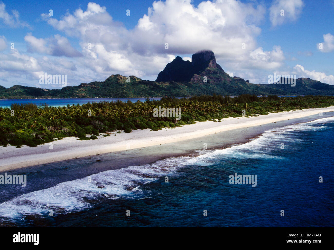 Plage de sable blanc et de palmiers avec des montagnes en arrière-plan, Bora Bora, îles de la société, Polynésie française. Banque D'Images