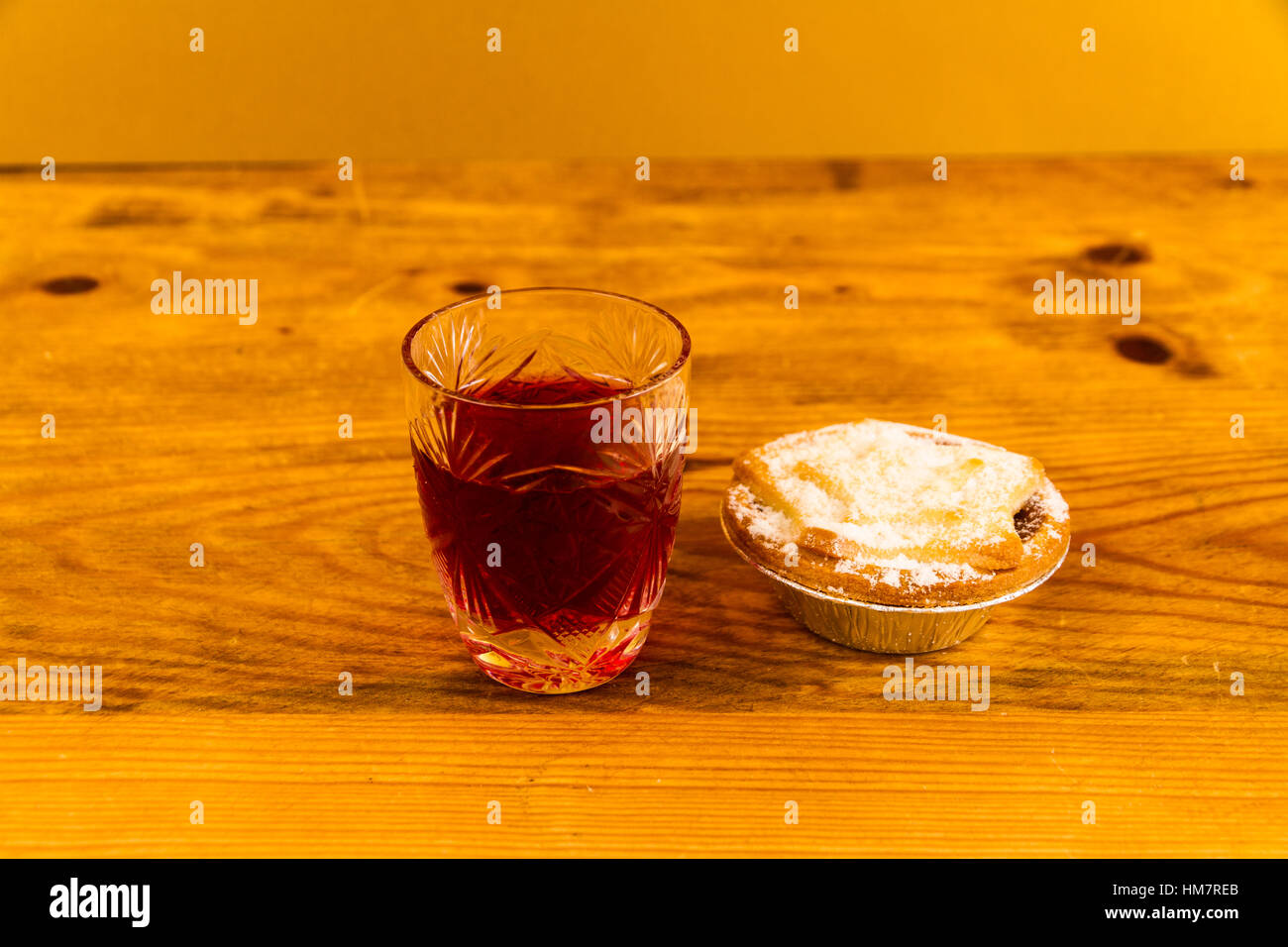 Verre à slow gin et mince pie, sur table en bois. Banque D'Images