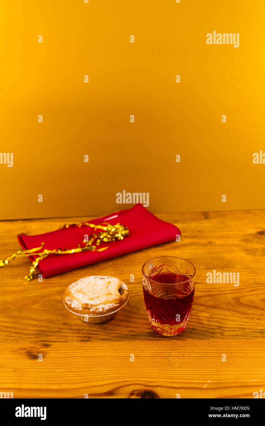 Verre à slow gin et mince pie, sur table en bois. Banque D'Images