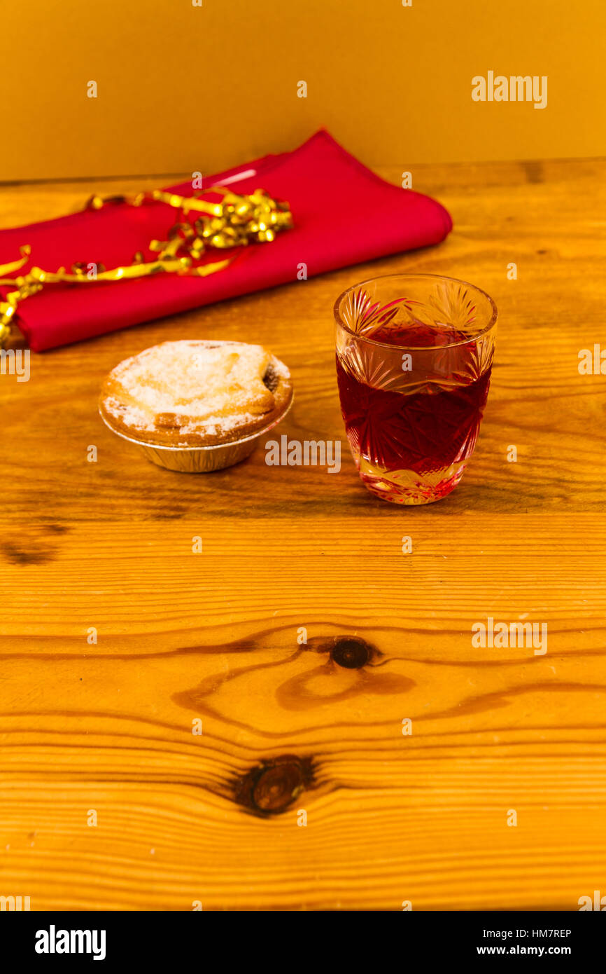 Verre à slow gin et mince pie, sur table en bois. Banque D'Images