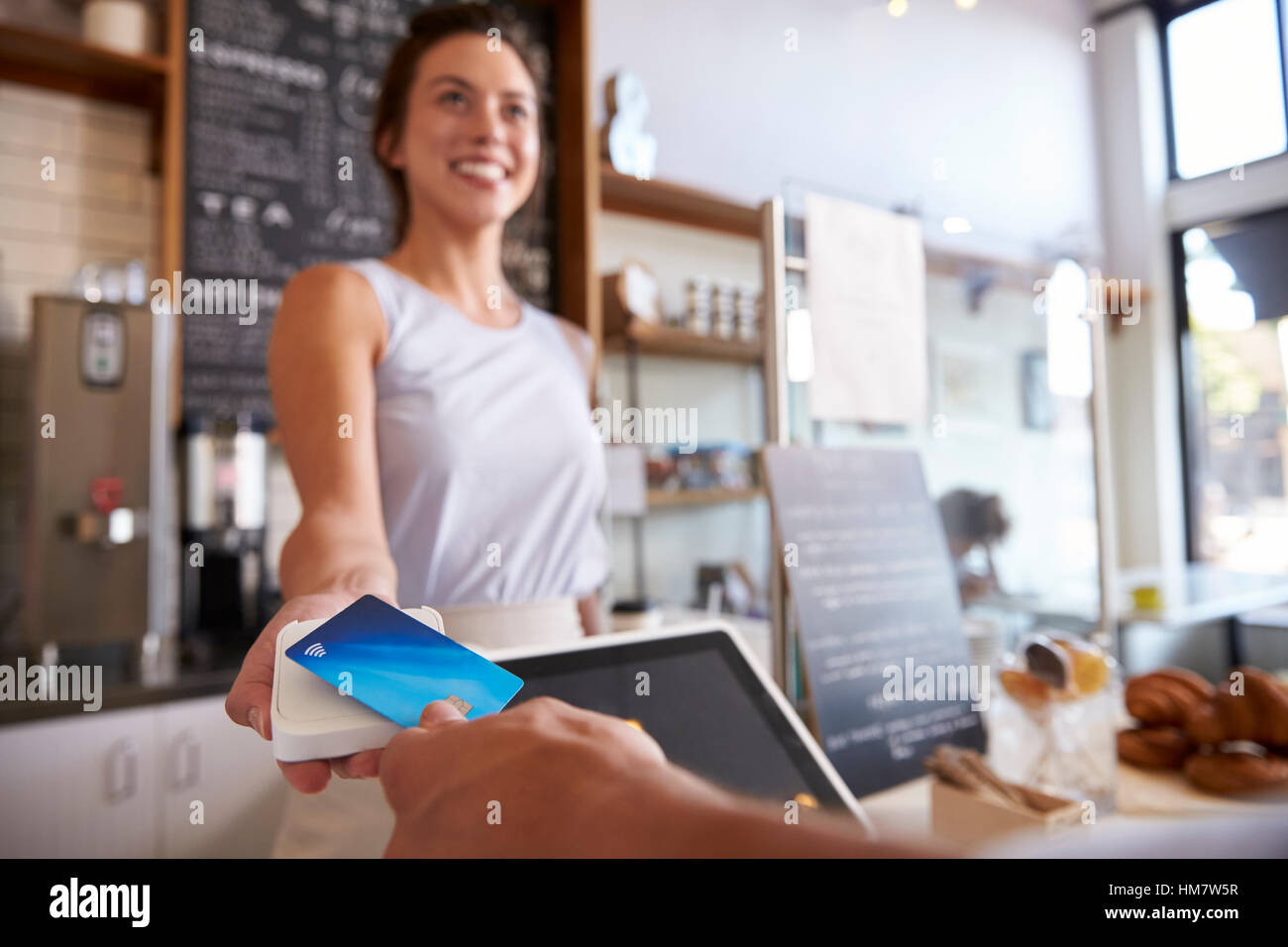 Du coffee shop client paie smiling waitress avec carte Banque D'Images