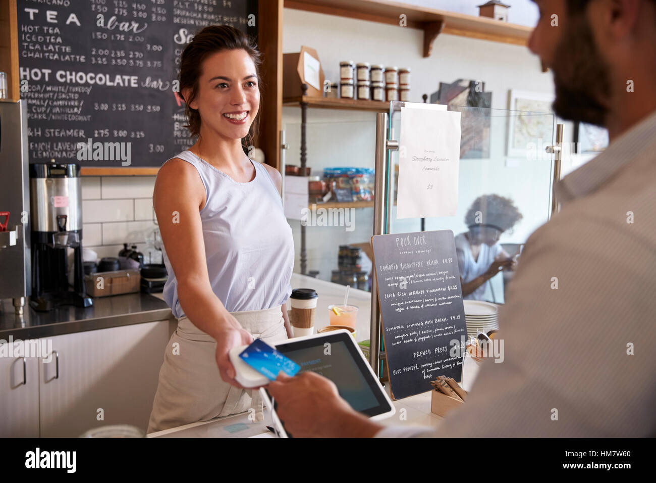 Du coffee shop client paie smiling waitress avec carte Banque D'Images
