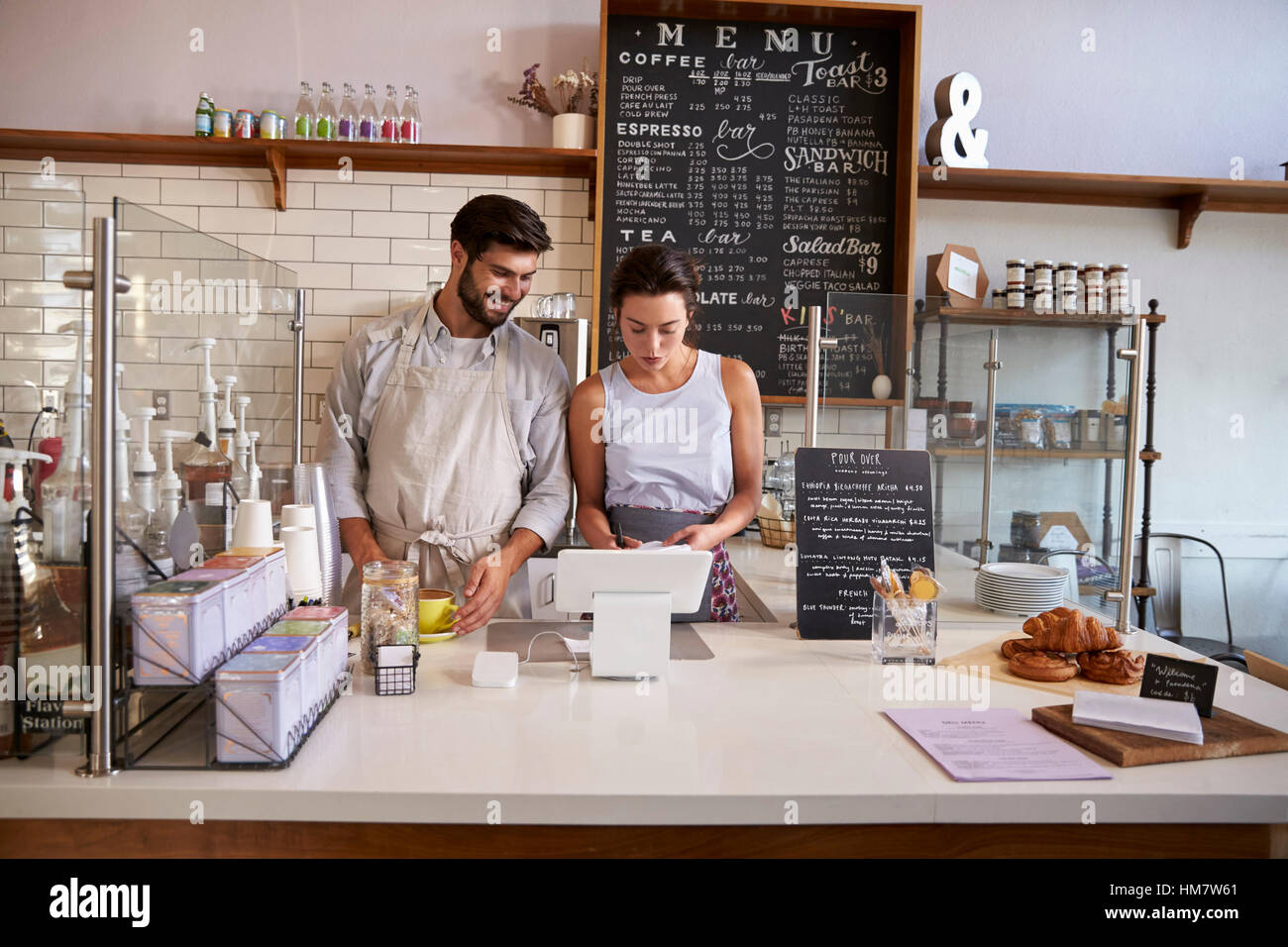 Couple travaillant ensemble à la caisse dans un coffee shop Banque D'Images
