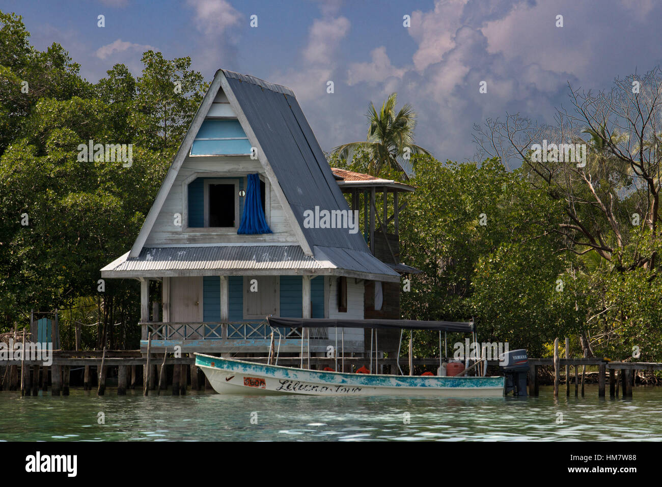 Maison sur pilotis sur l'eau avec des panneaux solaires et d'une végétation tropicale dense en arrière-plan, Bocas del Toro, Panama, la mer des Caraïbes. Cabine tropical sur t Banque D'Images