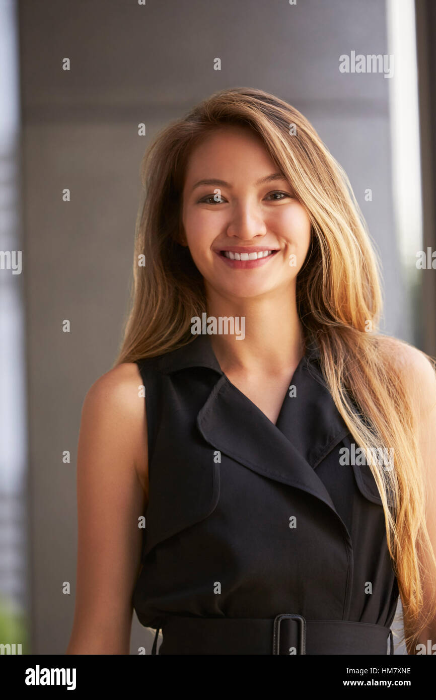 Young Asian businesswoman à la verticale, à l'appareil photo Banque D'Images