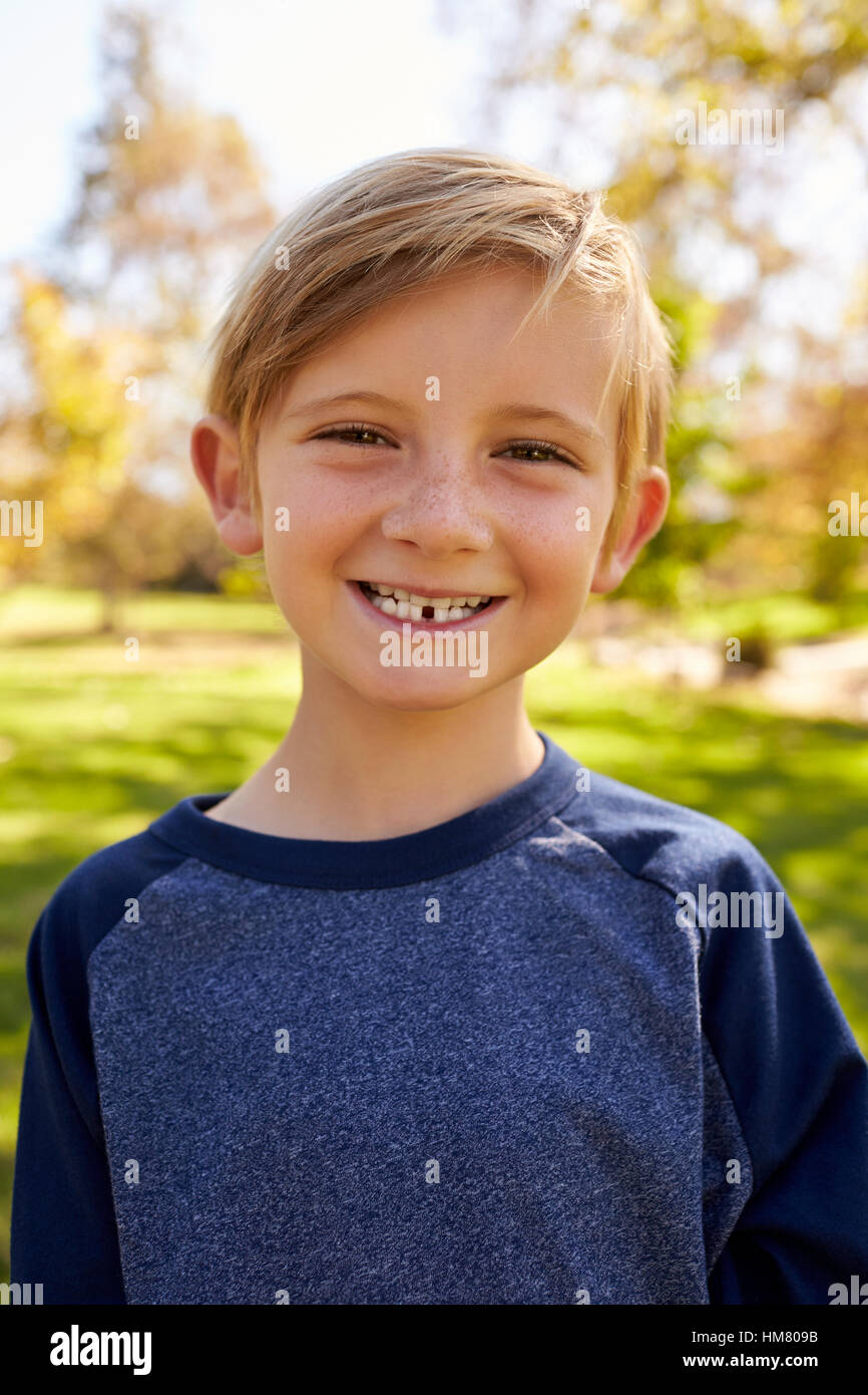 Sept ans garçon dans un parc, portrait vertical Banque D'Images