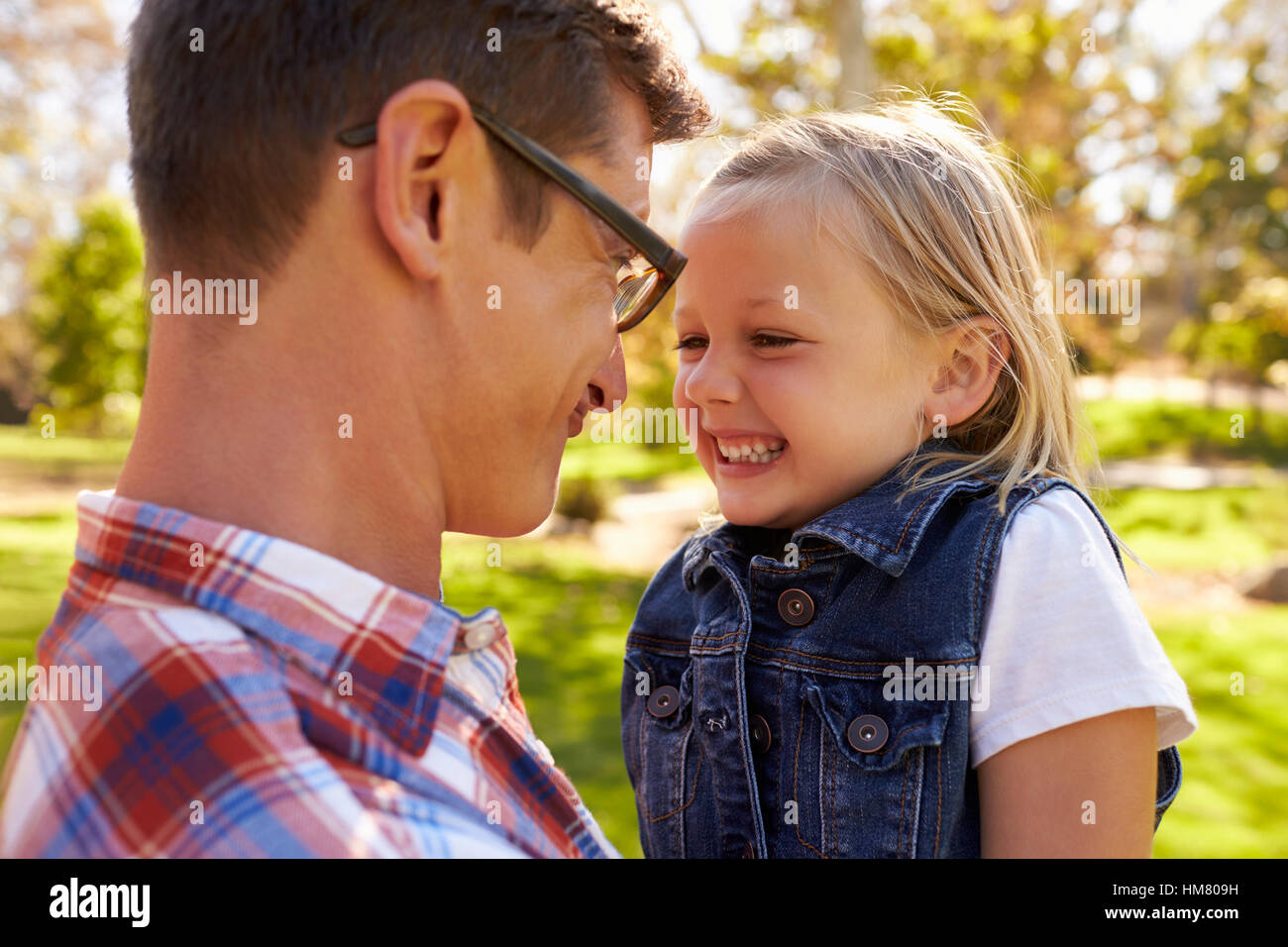 Père et fille pulling faces à l'autre dans un parc Banque D'Images