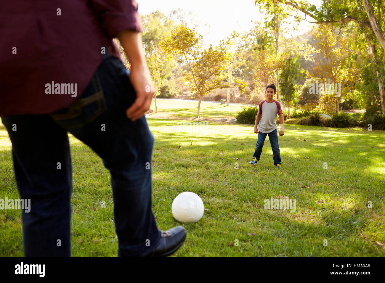 Football à sept coups de papa ans fils dans un parc, récolte Banque D'Images