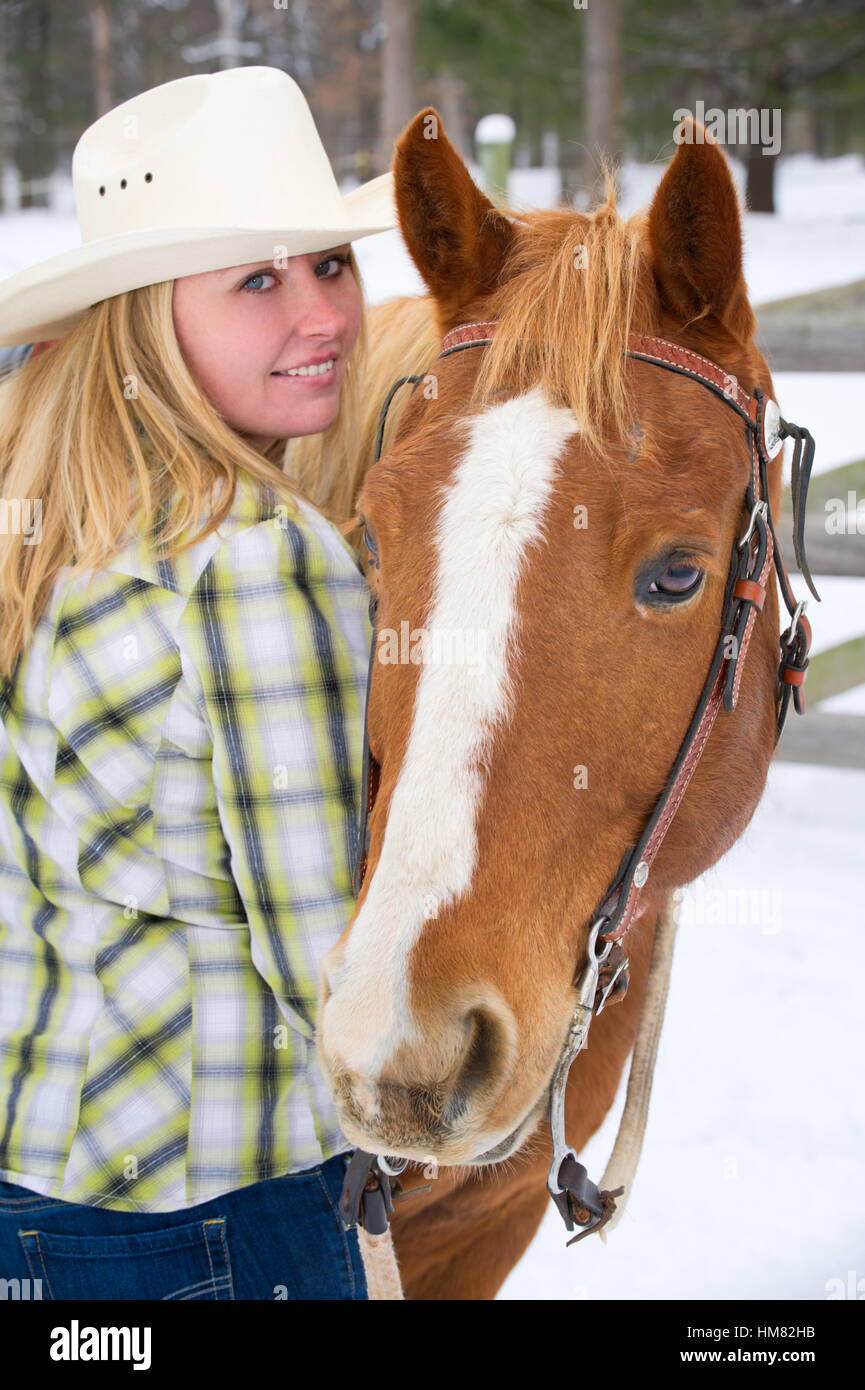 Cowgirl avec chapeau de cow-boy blanc, portant des vêtements d'équitation  western en mode portrait à cheval Photo Stock - Alamy