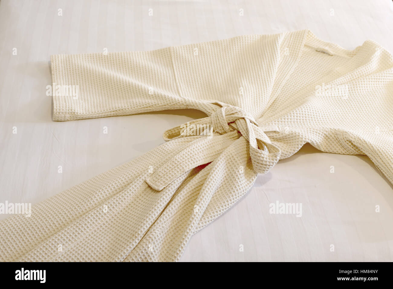 Peignoir blanc sur le lit Banque D'Images