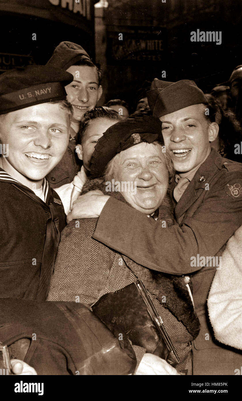 Jubilant American soldier hugs femme anglais maternelle et la victoire sourit lumière les visages des professionnels, hommes et les civils à Piccadilly Circus, Londres, célébrant la capitulation sans condition. L'Angleterre, le 7 mai 1945. La FPC. Melvin Weiss. (Armée) NARA DOSSIER #  : 111-SC-205398 LIVRE Guerres et conflits #  : 1354 Banque D'Images
