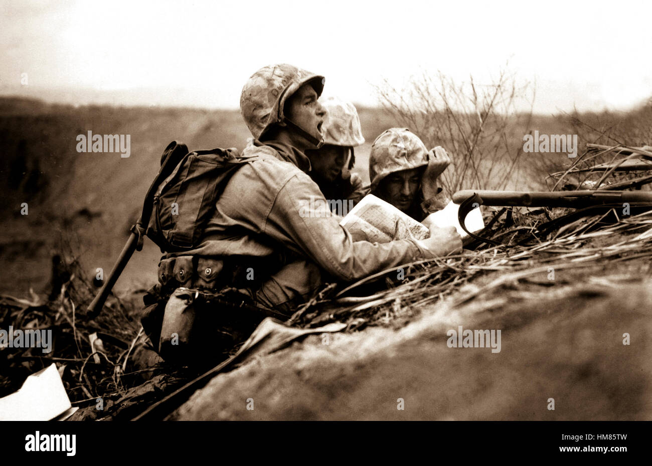 Observateur qui a repéré un nid de mitrailleuse trouve son emplacement sur une carte afin de pouvoir envoyer les informations à l'artillerie et des mortiers d'éliminer le poste. Iwo Jima, février 1945. Dreyfuss. (Marine Corps) Date exacte inconnue Shot #  FICHIER NARA : 127-N-109619 LIVRE Guerres et conflits #  : 1218 Banque D'Images