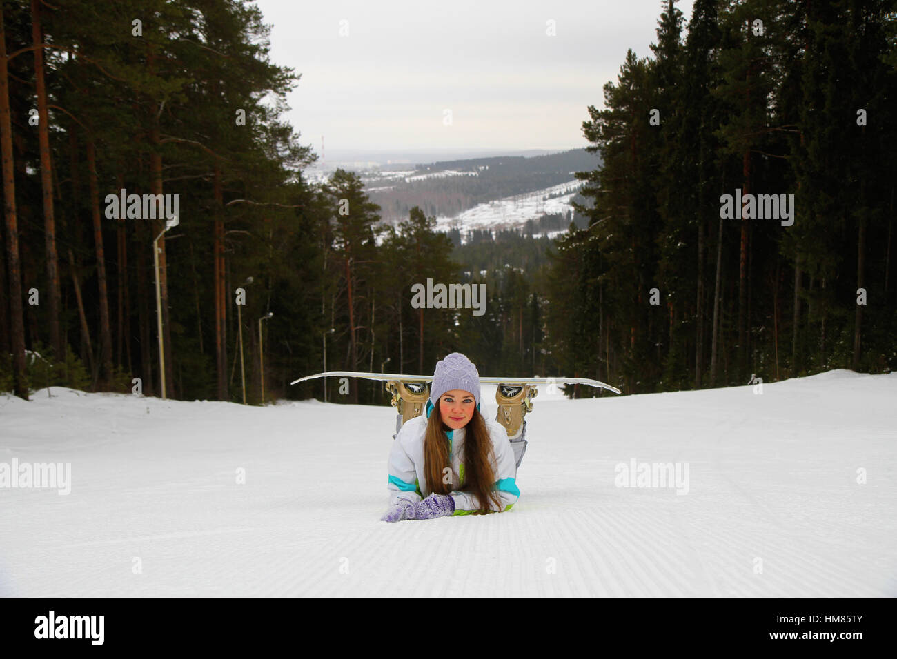 Femme souriante avec snowboard à la station de ski Banque D'Images