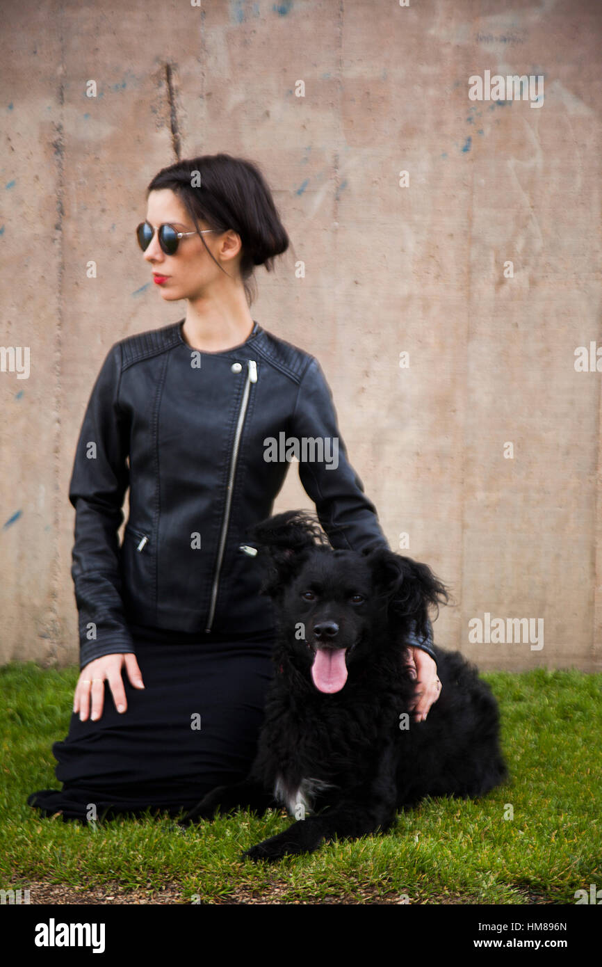 Portrait de jeunes femmes adultes en blouson de cuir avec chien noir Banque D'Images