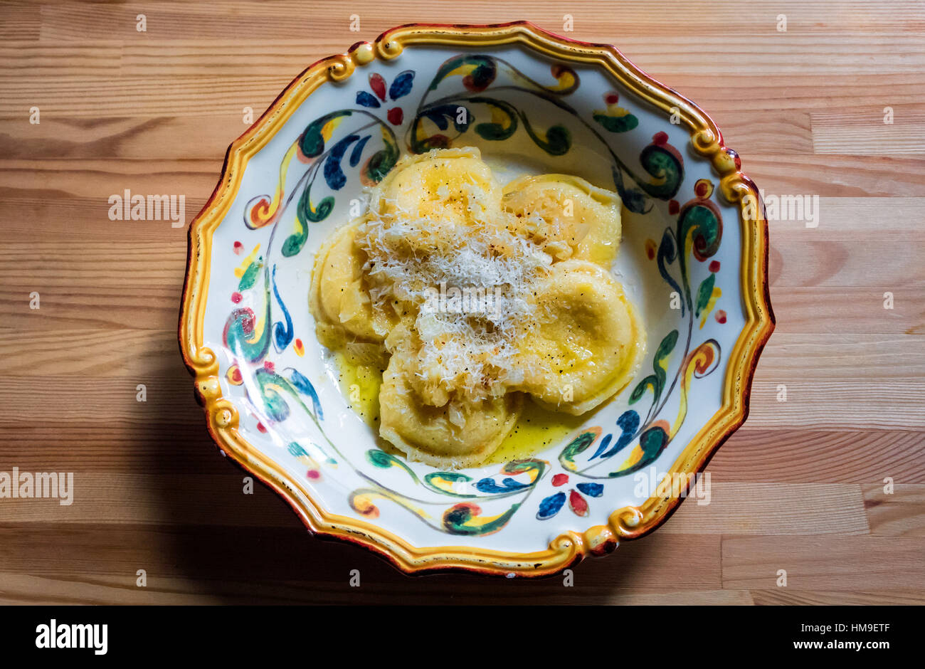 Raviolis avec beurre, oignons et fromage dans un bol italien coloré Banque D'Images