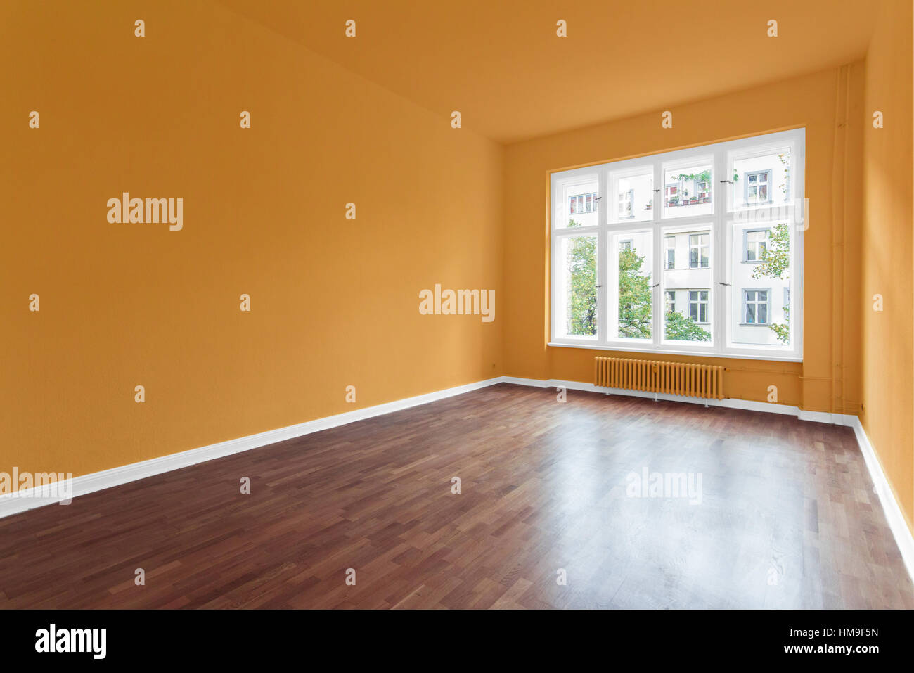 Salle vide avec des murs orange et plancher en bois Banque D'Images