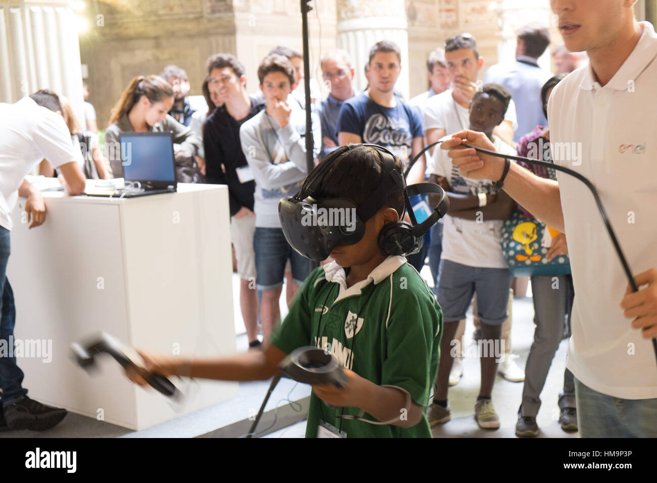 Homme mûr aide les gens d'utiliser correctement un système de RV. Florence, Italie Banque D'Images