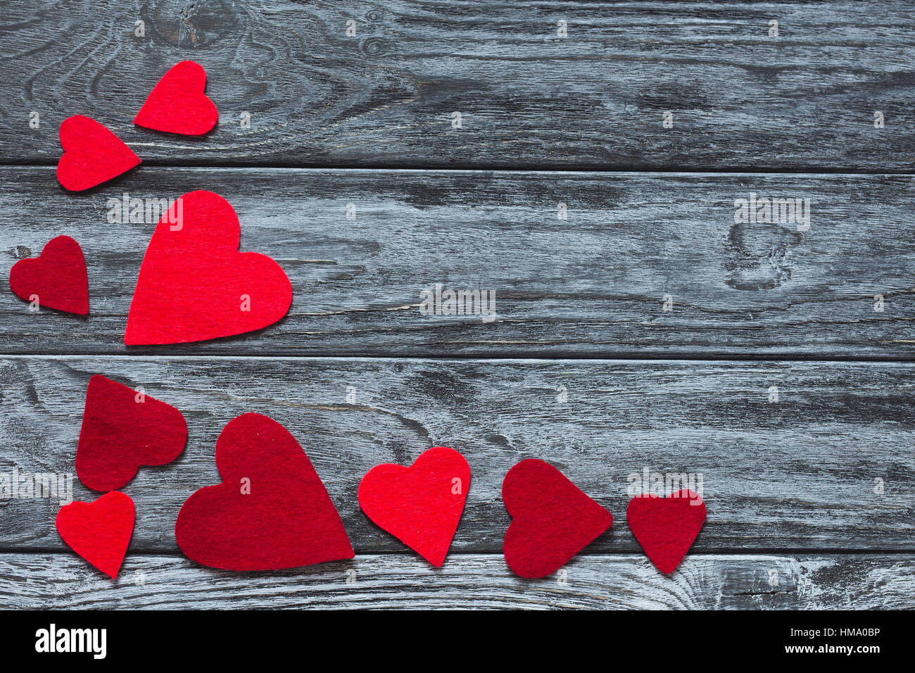 Valentines Day. Cœurs à la main sur bois tranche sur fond de bois gris vintage rustique. Valentine's Day love concept. Happy feelin Banque D'Images