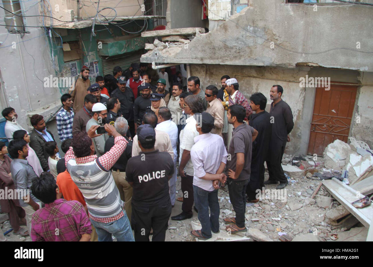 Les gens se rassemblent sur le lieu de la rencontre après la construction s'est effondré, en colonie de Neelum Karachi le Mercredi, Février 01, 2017. Deux personnes sont mortes et six autres blessées à gauche après l'aide d'étages. Banque D'Images