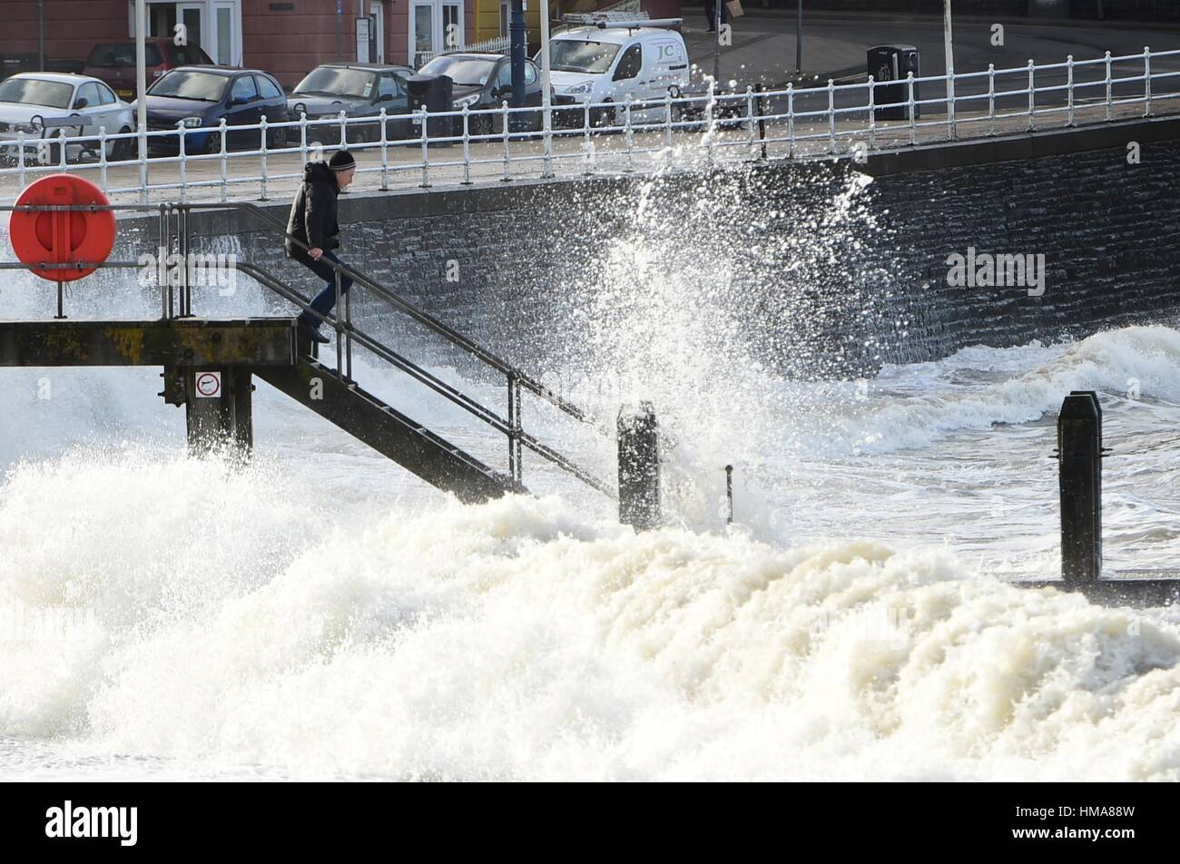 Ceredigion Aberystwyth Wales UK, jeudi 02 février 2017 UK Weather : un homme debout sur la promenade est d'examiner de près la mer comme les forts vents et marées haute ce matin apporter vagues se briser sur la promenade de la mer et de défense dans l'ouest du pays de Galles Aberystwyth, sur la côte. Plus forte et potentiellement néfaste, avec des rafales de vent supérieures à 60 km/h devraient frapper certaines parties du sud de l'UK demain Crédit photo : Keith morris/Alamy Live News Banque D'Images