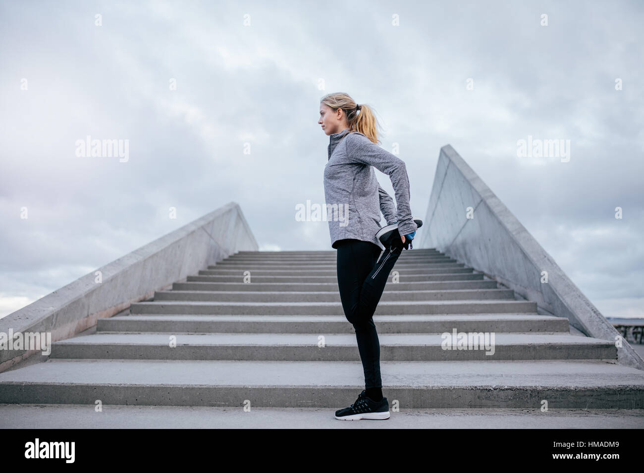 Side view of young female stretching sa jambe. Femme Fitness l'échauffement avant la course. Banque D'Images