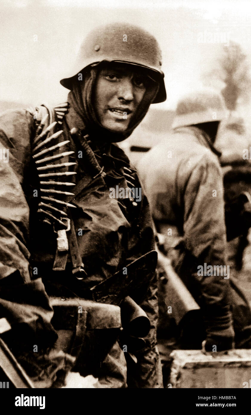 Un soldat nazi, lourdement armés, transporte des caisses de munitions de l'avant avec compagnon en territoire prises par leur contre-offensive dans cette scène du film allemands capturés. Belgique, décembre 1944. (Armée) Date exacte inconnue Shot #  FICHIER NARA : 111-SC-197561 LIVRE Guerres et conflits #  : 1070 Banque D'Images