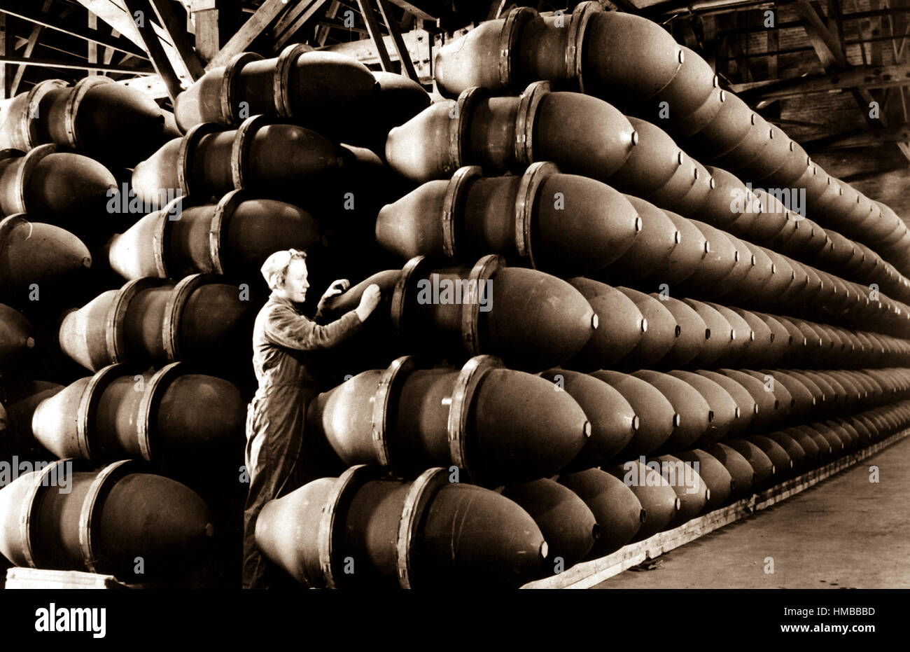 Une femme travailleuse de guerre des chèques de plus 1 000 livres cas bombe avant d'être remplis de charges d'explosifs mortels et expédié à bases alliées et de bataille dans le monde entier. Firestone Tire and Rubber Co. Omaha, NE, ca. Mai 1944. Acme. (OWI) Banque D'Images