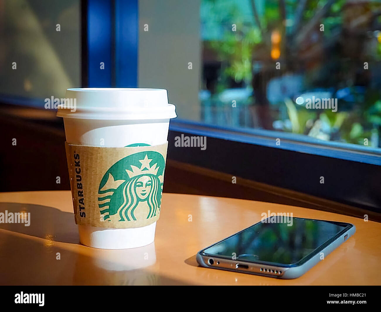 Bangkok, Thaïlande - 25 déc 2016 : une tasse de café Starbuck. boissons expresso chaud avec mobilephone arrière-plan. Banque D'Images